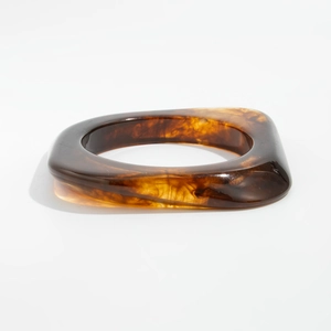 Détail macro du bracelet en résine ambre irrégulière avec texture épaisse géométrique