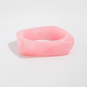 Macro shot of pink acrylic resin wide bangle with marbled texture and square shape