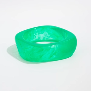 Macro detail of translucent green resin bangle with marble texture and gold foil flakes