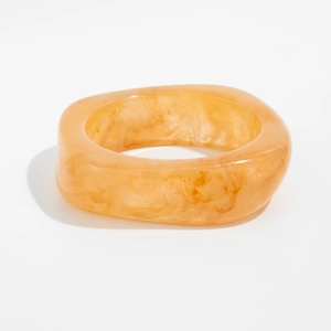 Macro detail of amber resin bracelet with gold foil marble texture and wide profile