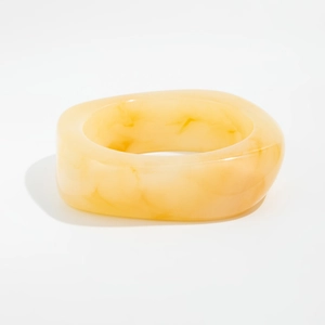 Macro shot of thick amber marble resin bangle with geometric square-round design details