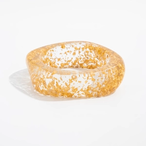 Detail of transparent resin bangle with gold foil flakes and smooth square edges
