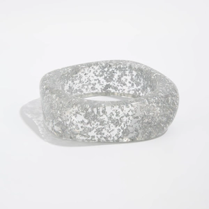 Close-up detail of silver foil flakes inside a wide transparent acrylic resin bangle