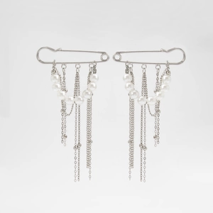 Détail d'épingles en métal argenté avec chaînes à franges et perles d'imitation