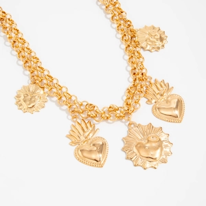 Dettaglio di collana dorata a strati vintage con pendenti a cuore e dischi radiali