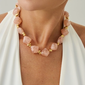Detail of pink marble resin beads and irregular gold metal spacers on a choker necklace