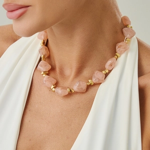 Detailed shot of pink resin beads and gold metal spacers on an irregular beaded choker
