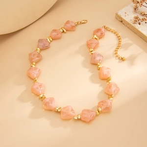 Detail view of pink marble resin beads necklace with golden spacers and adjustable chain