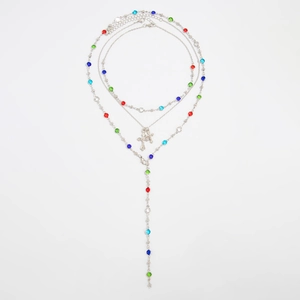Dettaglio macro della collana d'argento multistrato con cristalli colorati e croci