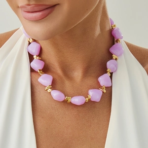 Detailed view of women's irregular light purple resin bead necklace with gold spacers