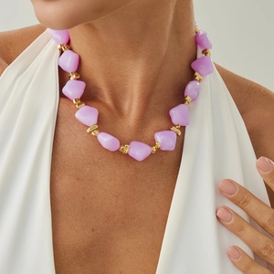 Detailed close-up of lavender irregular resin beads and gold spacer beads on a necklace