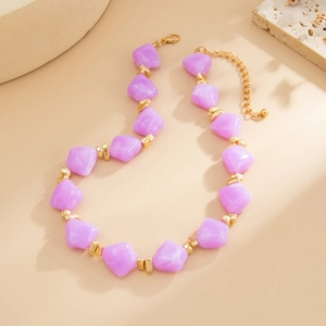 Detail of purple resin bead necklace featuring gold spacers and adjustable lobster clasp