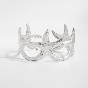 Detailweergave van zilveren zeesterarmband met getextureerde metalen afwerking