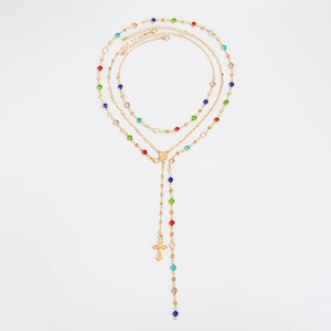 Dettaglio della collana tripla in oro con cristalli colorati e ciondolo a croce