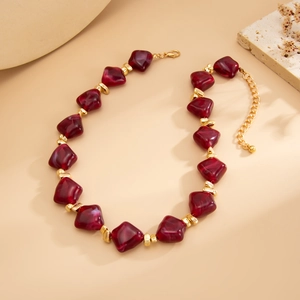 Detailed close-up of burgundy resin beads and gold spacers on a vintage choker necklace