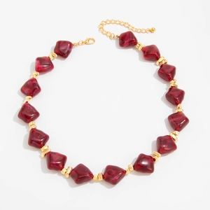 Detail view of irregular burgundy resin beads with gold spacers and lobster clasp