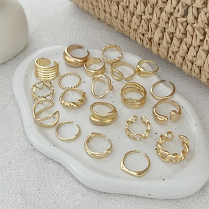 Détail d'un ensemble de bagues dorées ajustables avec design de lave et forme de cœur