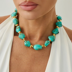 Macro detail of turquoise resin beads and irregular gold spacers on the choker necklace