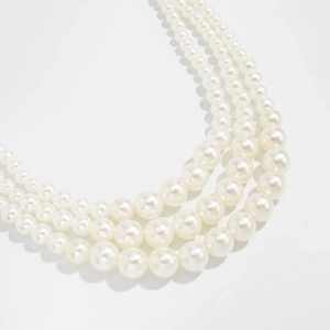 Close-up of elegant multi-layered faux pearl chain with glossy finish and white beads