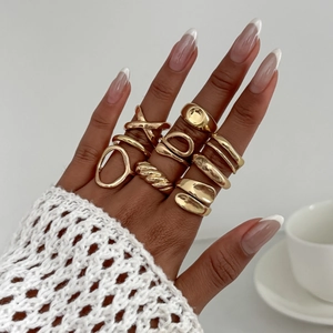 Détail de dix bagues dorées minimalistes avec motifs de lave liquide et formes ondulées