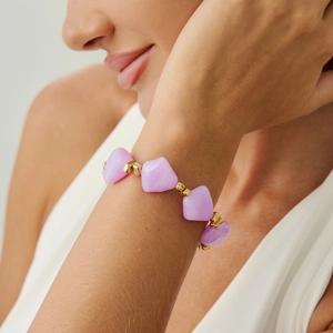 Close-up of irregular purple resin beads and gold spacers on a beaded choker necklace