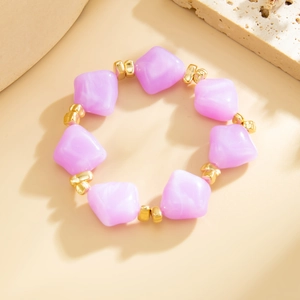 Detailed close-up of light purple faceted beads and gold metal spacers on a beaded necklace