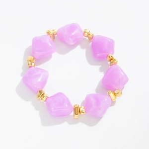 Detail of pink resin beaded bracelet with irregular marble pattern and golden spacers