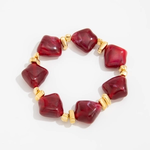 Detail of red irregular resin beads with white marbling and gold metal spacers bracelet