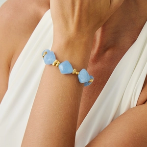 Detailed view of irregular light blue resin beads and golden metal spacers on the choker