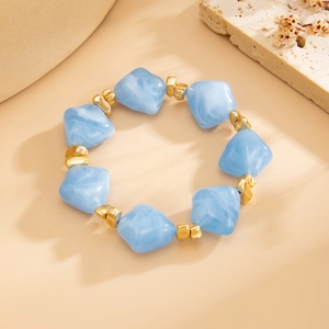 Detailed close-up of light blue marble resin beads and golden spacers on a stylish necklace