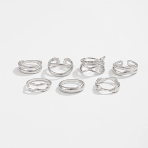 Vue détaillée de sept bagues empilables minimalistes en argent sur un fond blanc propre