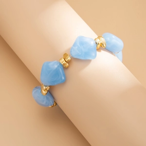 Detail of light blue faux marble resin beads and irregular gold spacers on choker necklace