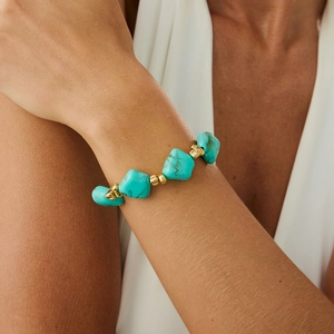 Macro view of bohemian turquoise bead bracelet with irregular stones and gold spacers