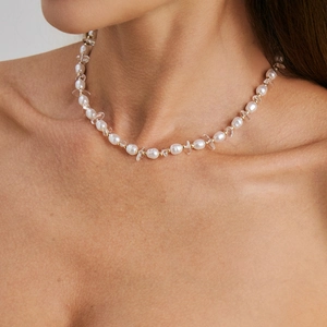 Detailopname van de bohemian zoetwaterparelketting met heldere stenen en gouden kralen