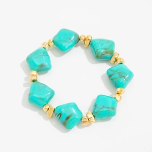 Detailed view of irregular turquoise resin beads and gold spacer beads on a choker necklace