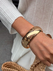 Macro shot of chunky gold resin bracelet with glossy mirror finish on a model wrist