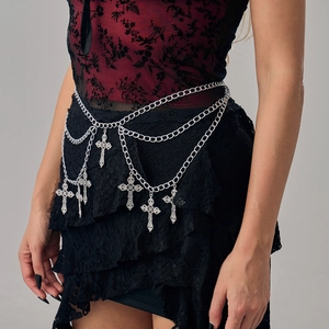 Close-up of gothic silver waist chain with intricate cross pendants on dark clothing