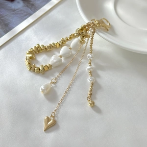 Elegant gold keychain with ceramic hearts, pearls, and a solid heart pendant for bags