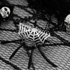 Detail van zilveren spinnenweb oorklem met gotische schedel voor Halloween-stijl