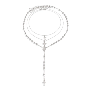 Detail van de zilveren gelaagde ketting met kruishanger en parelachtige ketting