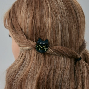 Détail d'une pince à cheveux chat noir à paillettes dorées sur cheveux bruns