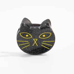 Gros plan d'une pince à cheveux chat noir pailleté avec détails jaunes pour Halloween