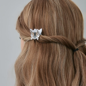 Détail d'une pince à cheveux motif araignée d'Halloween portée, motifs noir et orange