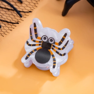 Vue détaillée d'une pince à cheveux araignée Halloween avec rayures noires et orange vif