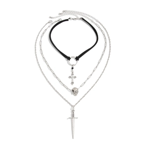 Detail of gothic layered necklace set with cross, skull, and dagger charms on white background