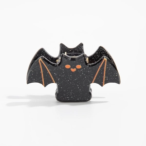 Gros plan d'une pince à cheveux chauve-souris noire pailletée d'Halloween avec détails orange
