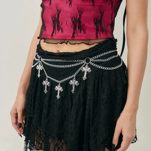 Detail of silver multilayered waist chain with gothic cross pendants and chain tassels