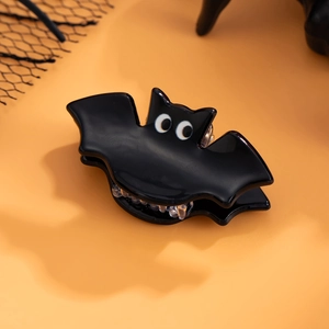 Détail d'une pince à cheveux en forme de chauve-souris noire brillante pour Halloween