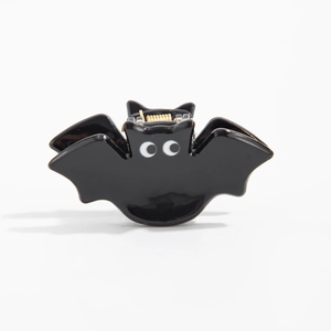 Détail d'une pince à cheveux chauve-souris noire avec de grands yeux et ressort doré