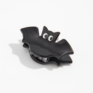 Gros plan d'une pince à cheveux chauve-souris noire brillante pour les styles d'Halloween